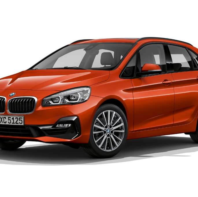 Tričetrtinski pogled od spredaj na BMW serije 2 Active Tourer kot model Sport Line BMW serije 2 Active Tourer kot model Sport Line, 220i F45, kovinska barva Sunset Orange, tričetrtinski pogled od spredaj