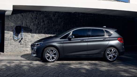 Priključni hibrid BMW 225xe Active Tourer, F45, stranski pogled Priključni hibrid BMW 225xe Active Tourer, F45, tričetrtinski stranski pogled pred stavbo