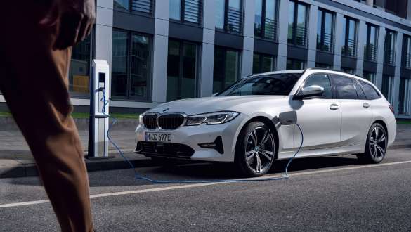 Priključni hibrid BMW serije 3 Touring, 2021, G21, tričetrtinski pogled od spredaj, polnjenje Priključni hibrid BMW serije 3 Touring, 2021, G21, tričetrtinski pogled od spredaj, polnjenje pred stavbo
