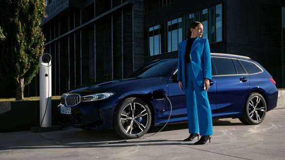 BMW serije 3 Touring, priključni hibrid, G21, tričetrtinski stranski pogled med polnjenjem BMW serije 3 Touring, priključni hibrid, G21, tričetrtinski stranski pogled med polnjenjem z manekenko