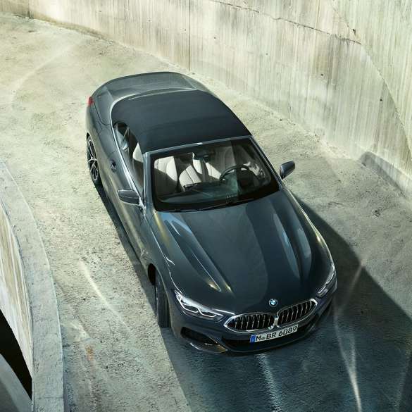 BMW M850i xDrive v kovinskem odtenku Dravit Grey z mehko črno streho iz ptičje perspektive. BMW M850i xDrive v kovinskem odtenku Dravit Grey z mehko črno streho iz ptičje perspektive.