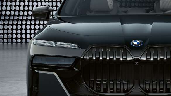 BMW M760e xDrive Limuzina, G70, osupljiva oblika prednjega dela BMW M760e xDrive Limuzina, G70, pokrov motorja in ledvička z M logotipom, dvobarvno lakiranje BMW Individual v kovinski barvi Black Sapphire, lakiranje BMW Individual v kovinski barvi Dravite Grey, pogled od blizu