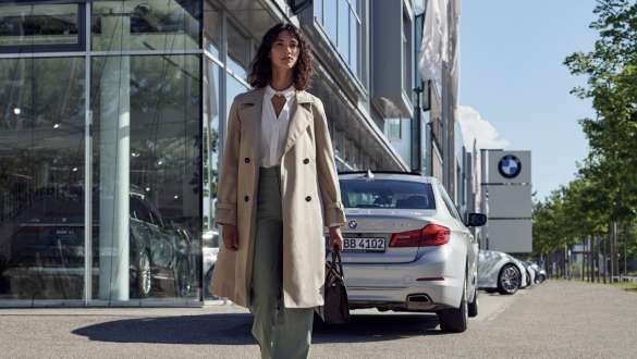 Ženska pred prodajnim salonom BMW BMW Service Inclusive, ženska pred prodajnim salonom BMW