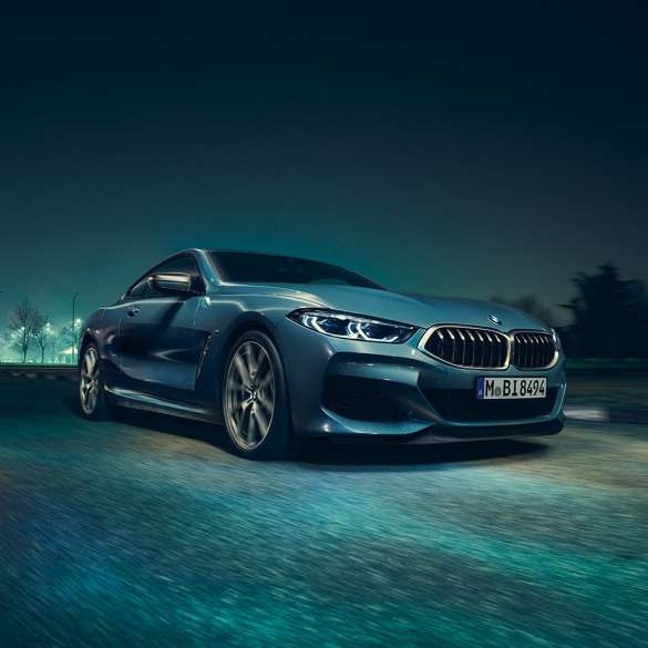 BMW M850i xDrive Coupé, v sprednjem polprofilu z leve strani. BMW M850i xDrive Coupé v kovinski barvi Barcelona Blue, v sprednjem polprofilu, med nočno vožnjo.