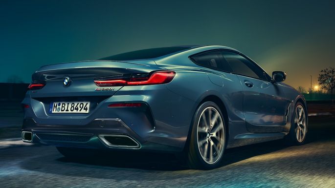 BMW M850i xDrive Coupé, z zadnje strani. BMW M850i xDrive Coupé v kovinski barvi Barcelona Blue, z zadnje strani, med nočno vožnjo.