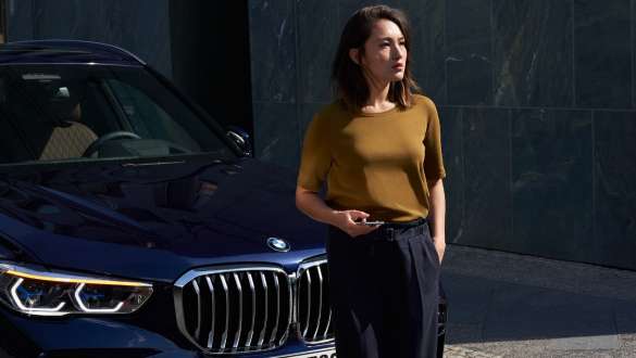 Ženska pred BMW Pomoč na cesti BMW, ženska pred BMW