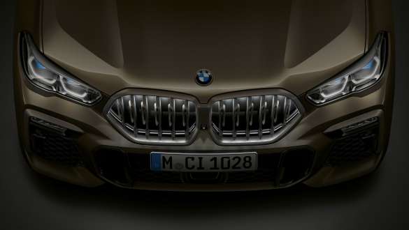Sprednji del BMW X6. Pogled od blizu na sprednji del BMW X6 z ledvičko BMW Iconic Glow iz ptičje perspektive.
