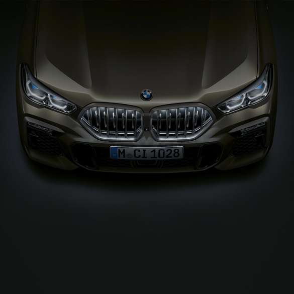 Sprednji del BMW X6. Pogled od blizu na sprednji del BMW X6 z ledvičko BMW Iconic Glow iz ptičje perspektive.