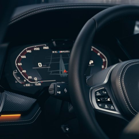 Sistemi za pomoč vozniku BMW. Pogled od blizu na notranjost BMW s poudarkom na instrumentni plošči.