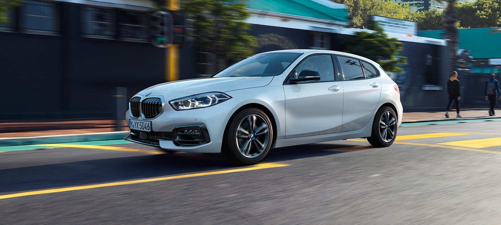 BMW serije 1 kot model Sport Line, tričetrtinski stranski pogled. BMW serije 1 kot model Sport Line v kovinski barvi Mineral White, tričetrtinski stranski pogled med vožnjo.