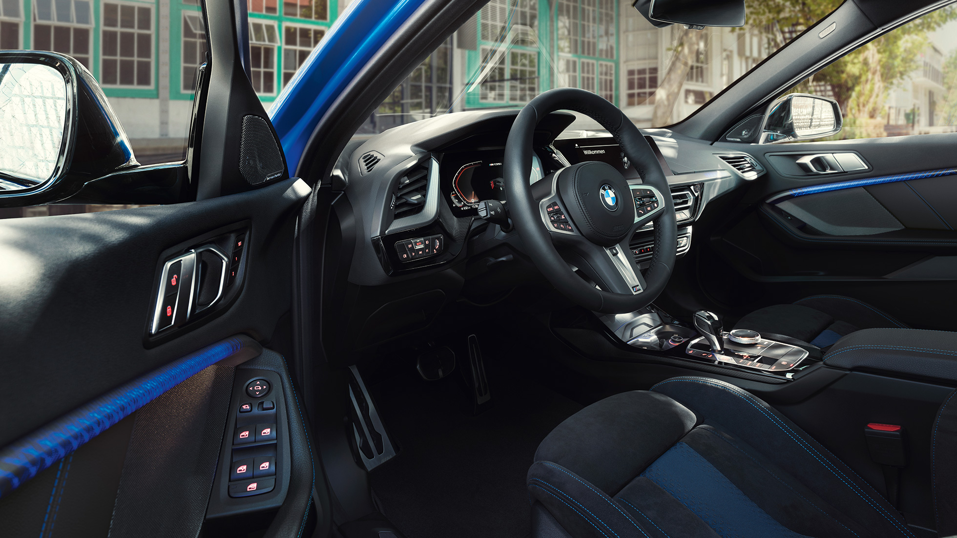 Kokpit BMW serije 1. Kokpit BMW serije 1 z M usnjenim volanom, medtem ko so voznikova vrata odprta.