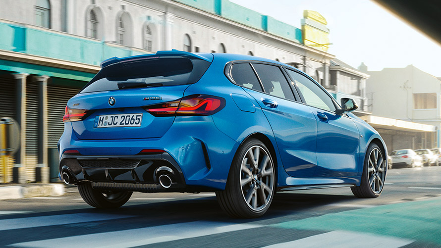 BMW serije 1, F40, tričetrtinski pogled od zadaj med vožnjo BMW serije 1, F40, kovinska barva Misano Blue, tričetrtinski pogled od zadaj med vožnjo