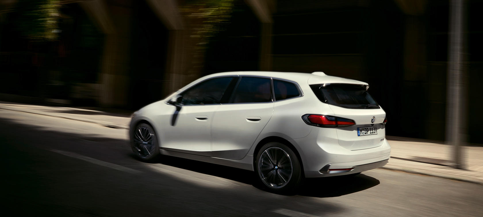 BMW serije 2 Active Tourer, U06, 2021, tričetrtinski pogled od zadaj med vožnjo BMW serije 2 Active Tourer, U06, 2021, kovinska barva Mineral Bela, tričetrtinski pogled od zadaj med vožnjo