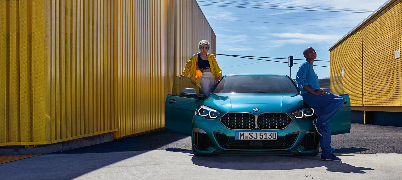 BMW serije 2 Coupé, F44, pogled od spredaj BMW serije 2 Gran Coupé, F44, kovinska barva Snapper Rocks Blue, pogled od spredaj z odprtimi vrati in dvema osebama pri vozilu