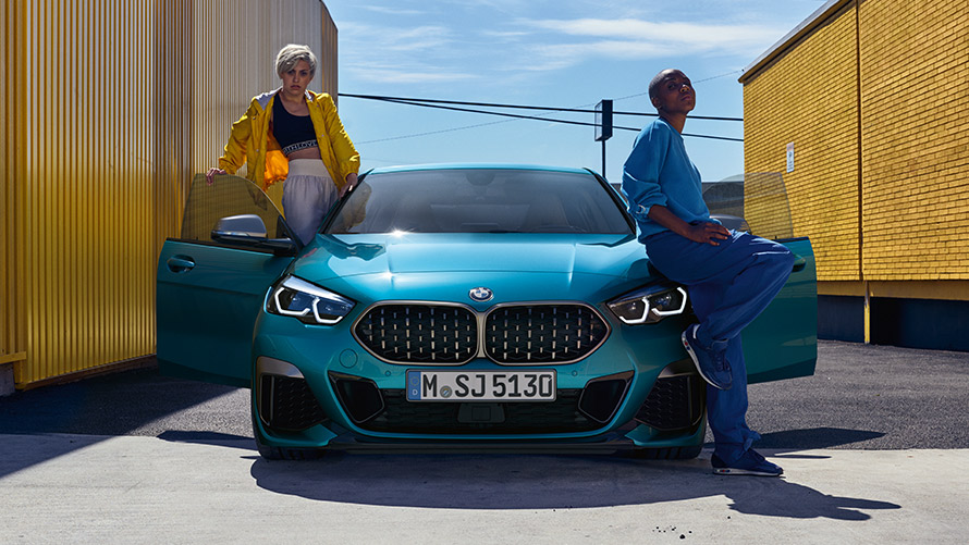 BMW serije 2 Coupé, F44, pogled od spredaj BMW serije 2 Gran Coupé, F44, kovinska barva Snapper Rocks Blue, pogled od spredaj z odprtimi vrati in dvema osebama pri vozilu