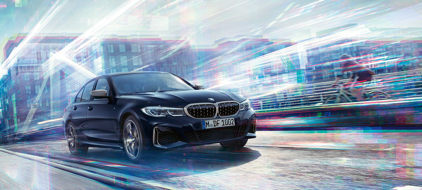 BMW serije 3 Limuzina, BMW M340i xDrive. Tričetrtinski stranski pogled na BMW M340i xDrive pri vožnji v mestnem okolju.