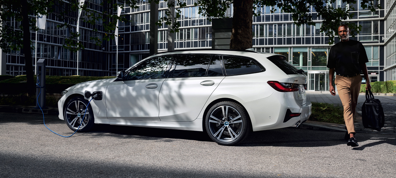 Priključni hibrid BMW serije 3 Touring, 2021, G21, tričetrtinski stranski pogled, polnjenje Priključni hibrid BMW serije 3 Touring, 2021, G21, tričetrtinski stranski pogled, polnjenje z manekenko
