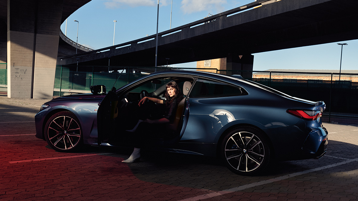 Stranski pogled na platišča iz lahke zlitine, BMW serije 4 Coupé, G22, 2020 BMW serije 4 Coupé, G22, 2020, kovinska barva Arctic Race Blue, stranski pogled na platišča iz lahke zlitine, maneken v avtomobilu z odprtimi vrati