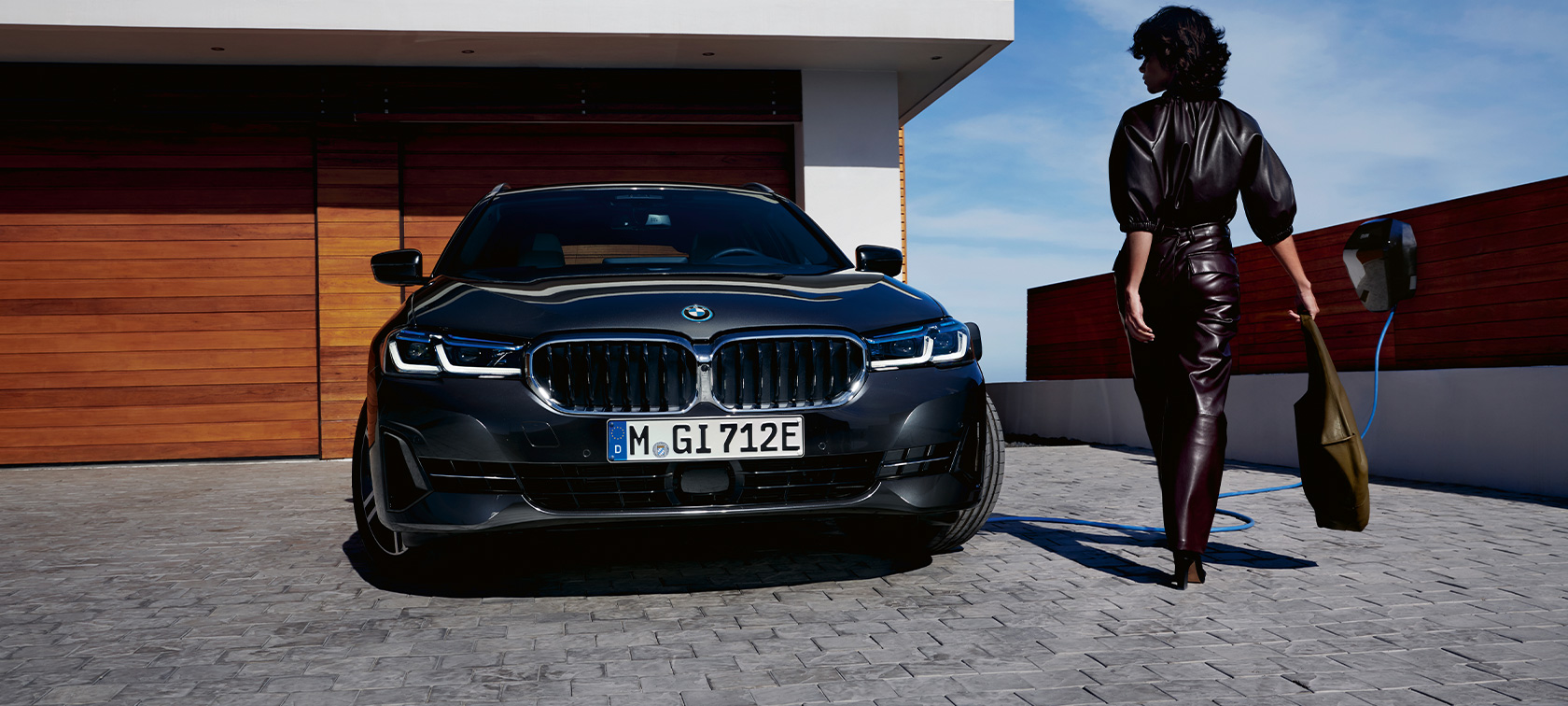Priključni hibrid BMW serije 5 Touring, 2021, G31, pogled od spredaj, polnjenje Priključni hibrid BMW serije 5 Touring, 2021, G31, pogled od spredaj, polnjenje z manekenko