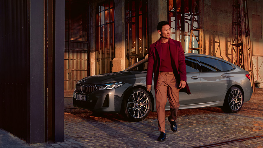 BMW serije 6 Gran Turismo, 640i xDrive, G32, barva Bernina Grey BMW serije 6 Gran Turismo, 640i xDrive, G32, barva Bernina Grey, moški stoji pred BMW v stranskem pogledu