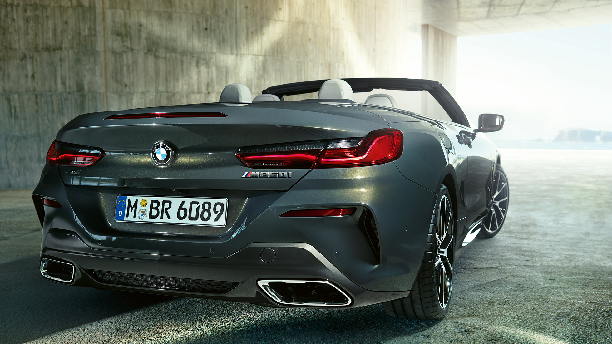 BMW M850i xDrive v kovinskem odtenku Dravit Grey, tričetrtinski pogled od zadaj desno. BMW M850i xDrive v kovinskem odtenku Dravit Grey, tričetrtinski pogled od zadaj desno.