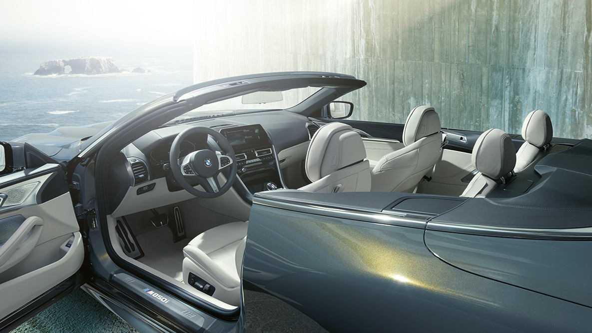 BMW M850i xDrive v kovinskem odtenku Dravit Grey, notranjost, mehka streha in odprta vrata. BMW M850i xDrive v kovinskem odtenku Dravit Grey, notranjost, mehka streha in odprta vrata.