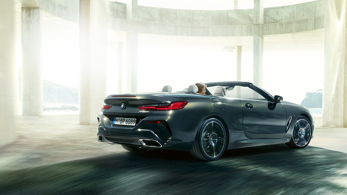 BMW M850i xDrive, pogled s strani med vožnjo z odprto mehko streho. BMW M850i xDrive, pogled s strani med vožnjo z odprto mehko streho.