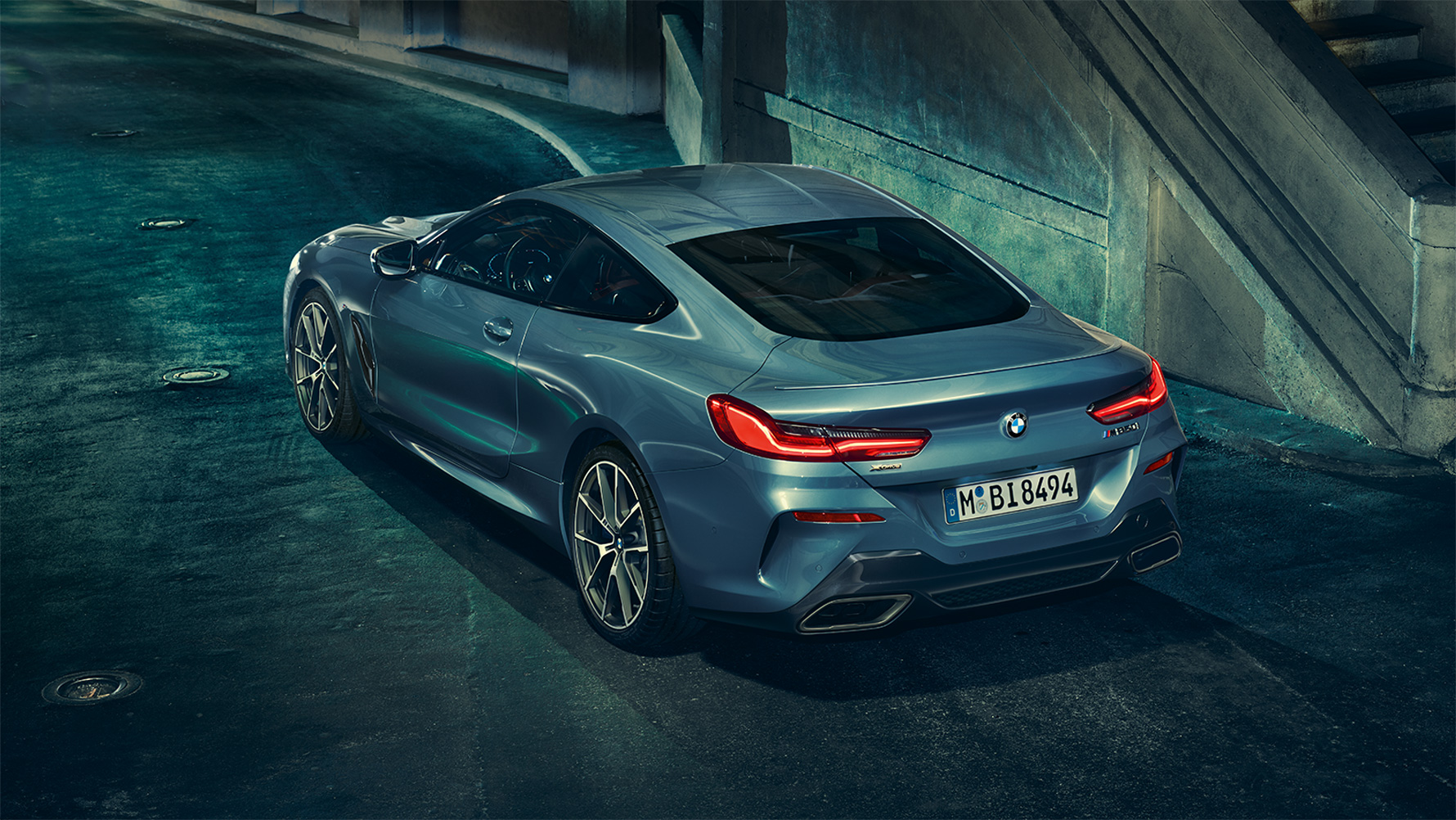 BMW serije 8 Coupé, tričetrtinski pogled od zadaj Tričetrtinski pogled od zadaj BMW serije 8 Coupé ponoči pred mestnim ozadjem.