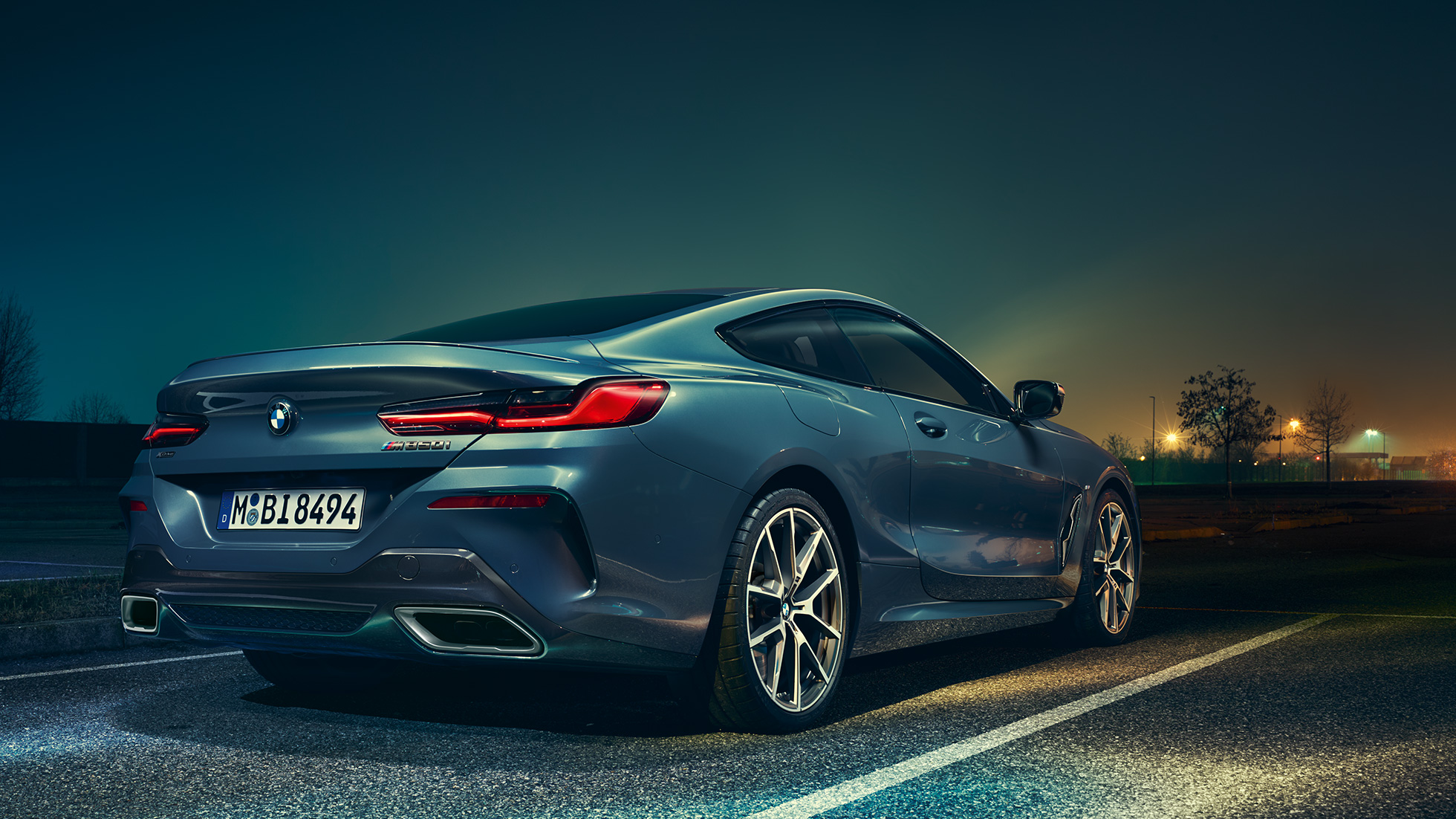BMW serije 8 Coupé, tričetrtinski pogled od zadaj. BMW serije 8 Coupé, tričetrtinski pogled od zadaj, stoji pred nočno kuliso.