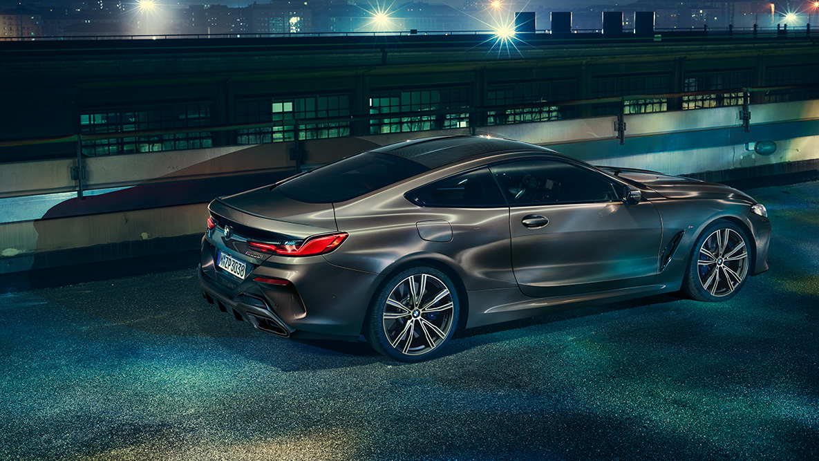 Mirujoč posnetek BMW serije 8 Coupé. Mirujoč posnetek BMW serije 8 Coupé z opremo BMW Individual od strani v mestnem okolju ponoči.