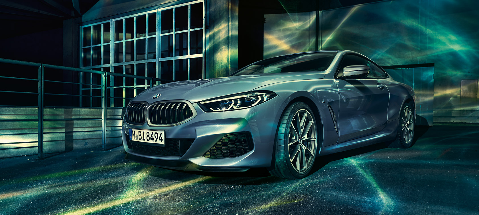 BMW serije 8 Coupé, tričetrtinski posnetek od spredaj. BMW serije 8 Coupé, tričetrtinski posnetek od spredaj, pred industrijsko stavbo.