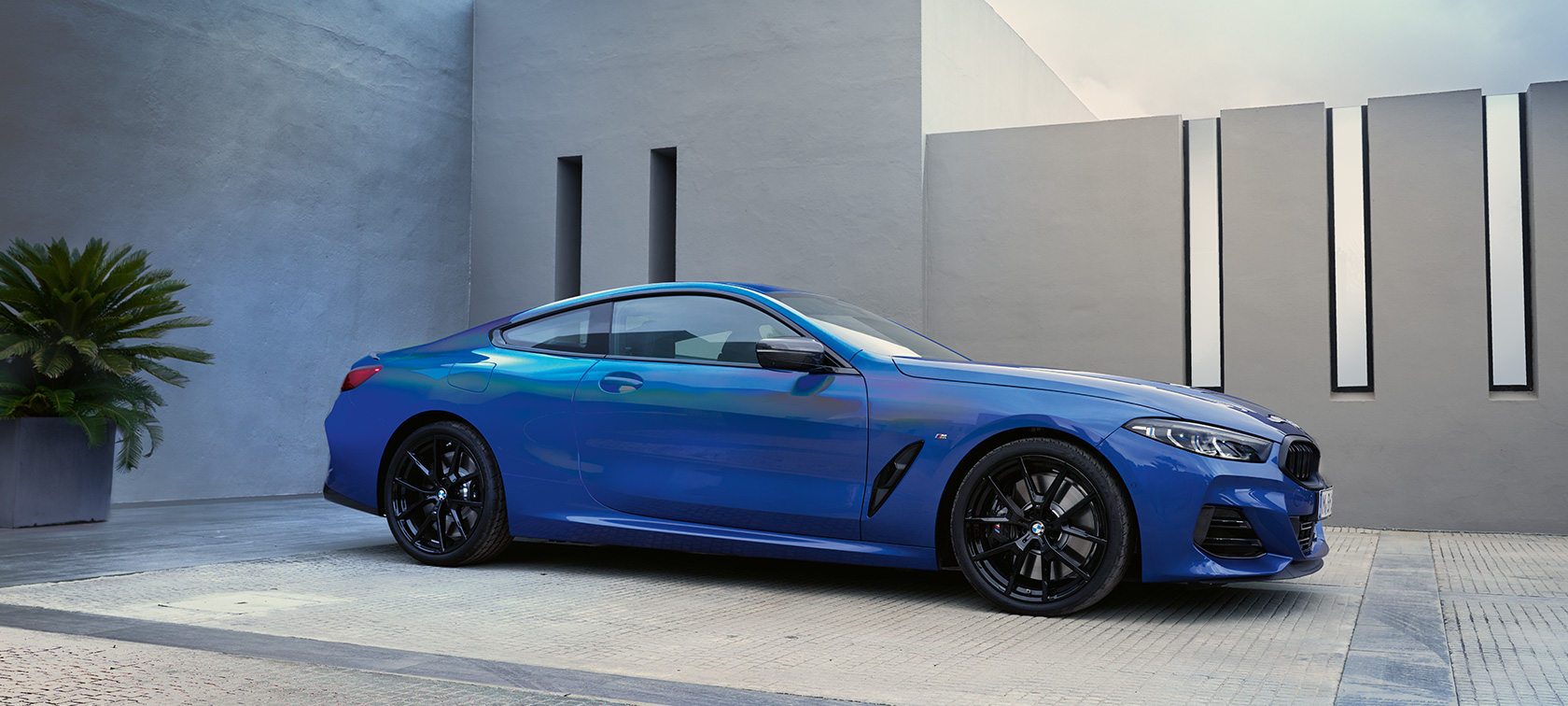 BMW serije 8 Coupé, G15, LCI, osvežitev 2022, kovinska barva M Portimao Blue, stranski pogled med mirovanjem pred steno