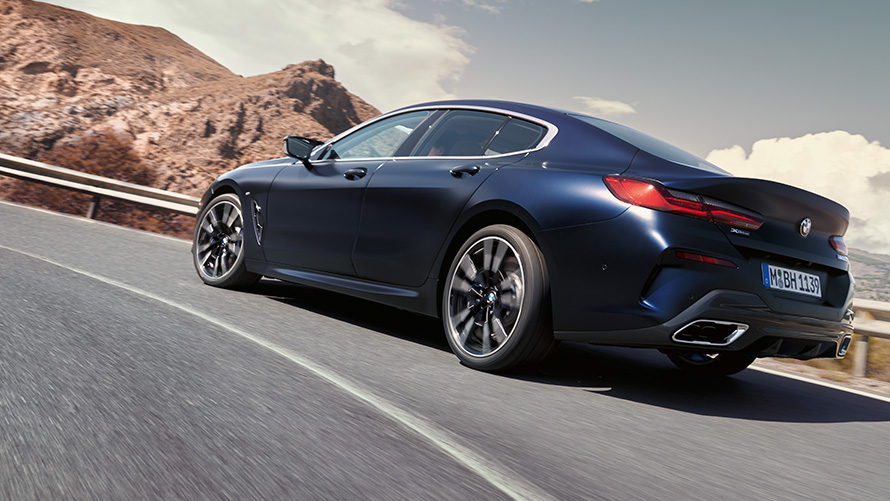 BMW 840i xDrive Gran Coupé G16 LCI Facelift 2022 vožnja po gorski cesti BMW 840i xDrive Gran Coupé, G16, LCI, osvežitev 2022, kovinska barva M Portimao Blue, tričetrtinski pogled od zadaj med vožnjo po gorski cesti