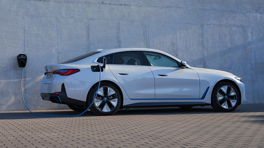 BMW i4 eDrive40, G26, 2021, barva Mineral White, stranski pogled z BMW Wallbox BMW i4 eDrive40, G26, 2021, barva Mineral White, stranski pogled na na steno hiše z BMW Wallbox