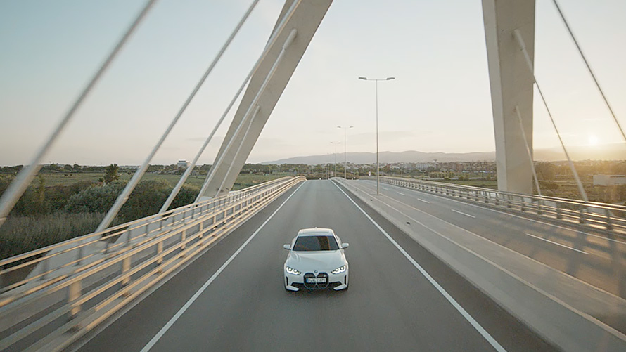 BMW i4 eDrive40, G26, 2021, tričetrtinski pogled od spredaj med vožnjo BMW i4 eDrive40, G26, 2021, barva Mineral White, tričetrtinski pogled od spredaj med vožnjo