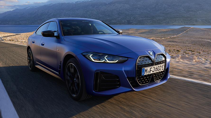 BMW i4 M50, G26, 2021, tričetrtinski pogled od spredaj BMW i4 M50, G26, 2021, kovinska barva M Portimao Blue, tričetrtinski pogled od spredaj med vožnjo po cesti