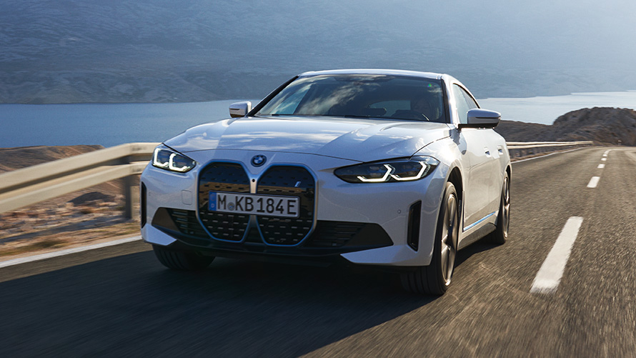 BMW i4 eDrive40, G26, 2021, tričetrtinski pogled od spredaj med vožnjo BMW i4 eDrive40, G26, 2021, barva Mineral White, tričetrtinski pogled od spredaj med vožnjo