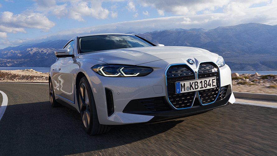 BMW i4 eDrive40, G26, 2021, tričetrtinski pogled od spredaj med vožnjo BMW i4 eDrive40, G26, 2021, barva Mineral White, tričetrtinski pogled od spredaj med vožnjo