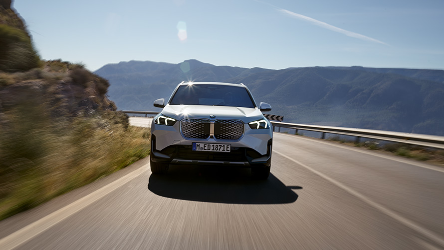 BMW iX1, U11, BEV, 2022, pogled od spredaj BMW iX1, U11, BEV, 2022, kovinska barva Mineral White, pogled od spredaj, vožnja po gorski cesti