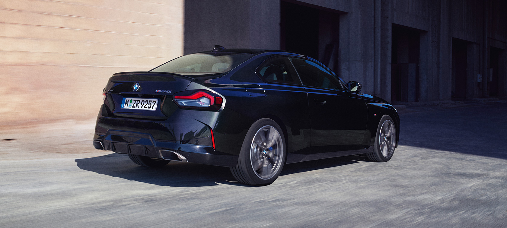 BMW M240i xDrive Coupé, G42, 2021,tričetrtinski pogled od zadaj BMW M240i xDrive Coupé, G42, 2021, kovinska barva Black Sapphire, tričetrtinski pogled od zadaj med vožnjo