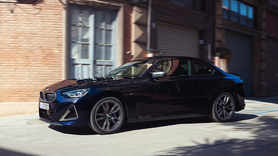 BMW serije 2 Coupé, G42, 2021, tričetrtinski stranski pogled BMW serije 2 Coupé, G42, 2021, kovinska barva Thundernight, tričetrtinski stranski pogled med mirovanjem pred skladiščem
