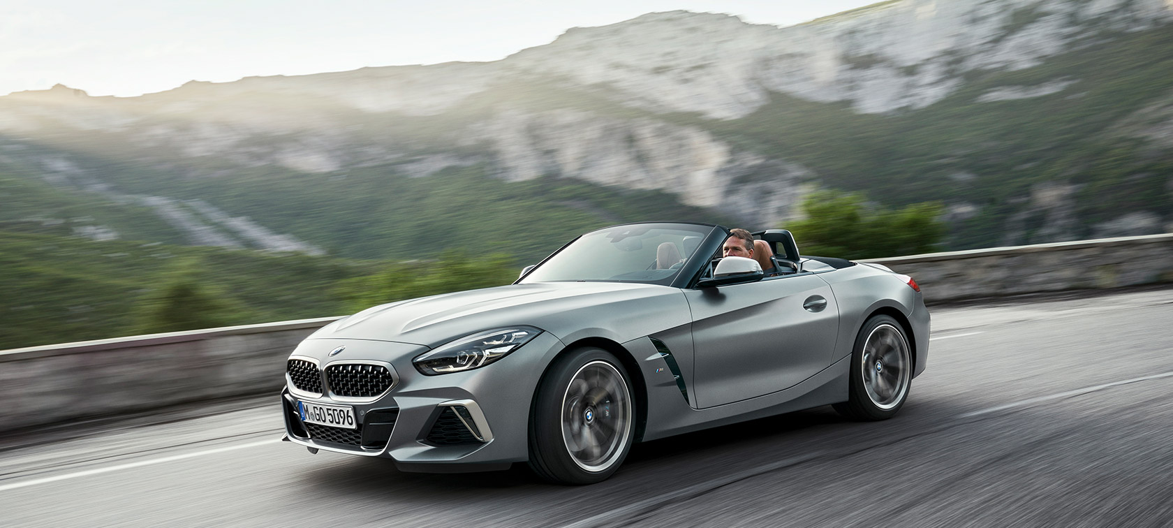 BMW Z4 M40i G29 med vožnjo z gorsko kuliso BMW Z4 Roadster M40i, G29 2019 Cabrio, lakiranje BMW Individual v kovinski barvi Frozen Grey, tričetrtinski pogled od spredaj med vožnjo z gorsko kuliso
