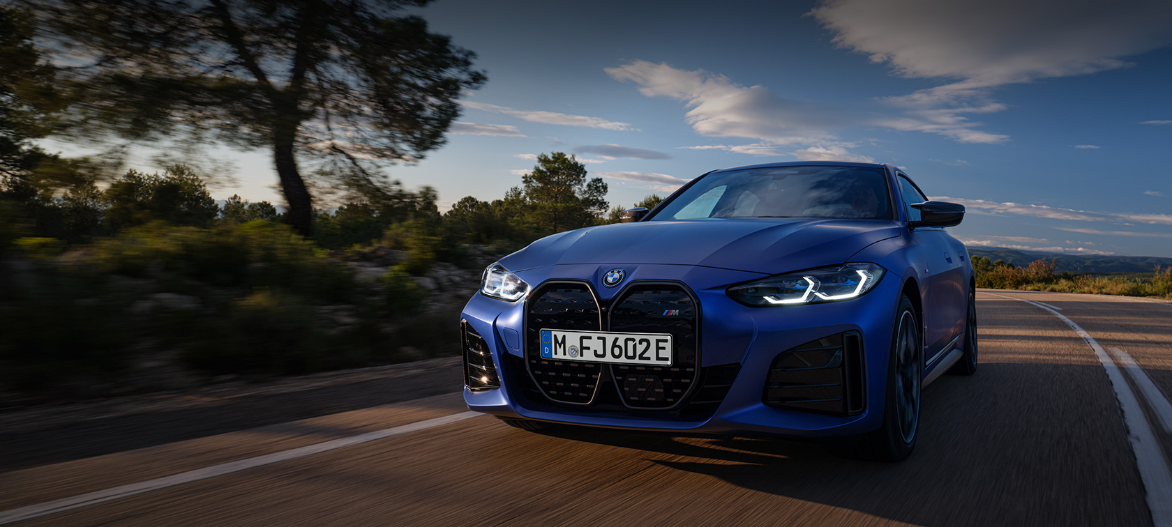 BMW i4 M50, G26, 2021, lakiranje BMW Individual v kovinski barvi Frozen Portimao Blue, tričetrtinski pogled od spredaj med vožnjo