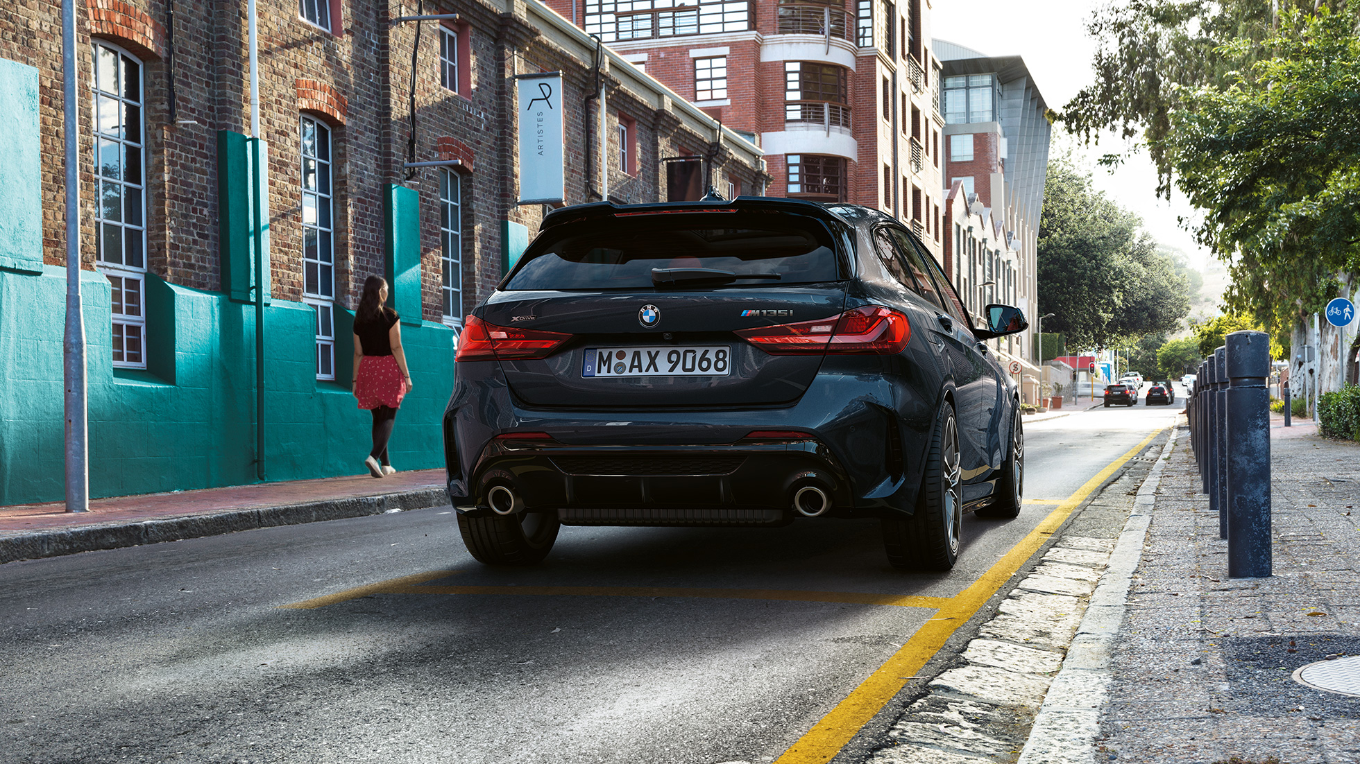 BMW M135i xDrive, pogled od zadaj. BMW M135i xDrive v kovinski barvi Black Sapphire, vzvratno parkiranje.