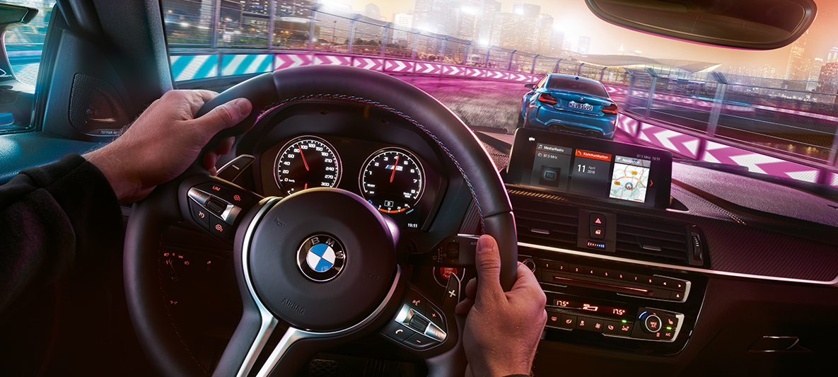 Kokpit BMW M2 Competition Dva BMW M2 Competition v dirkalnih razmerah ponoči, pogled iz kokpita.