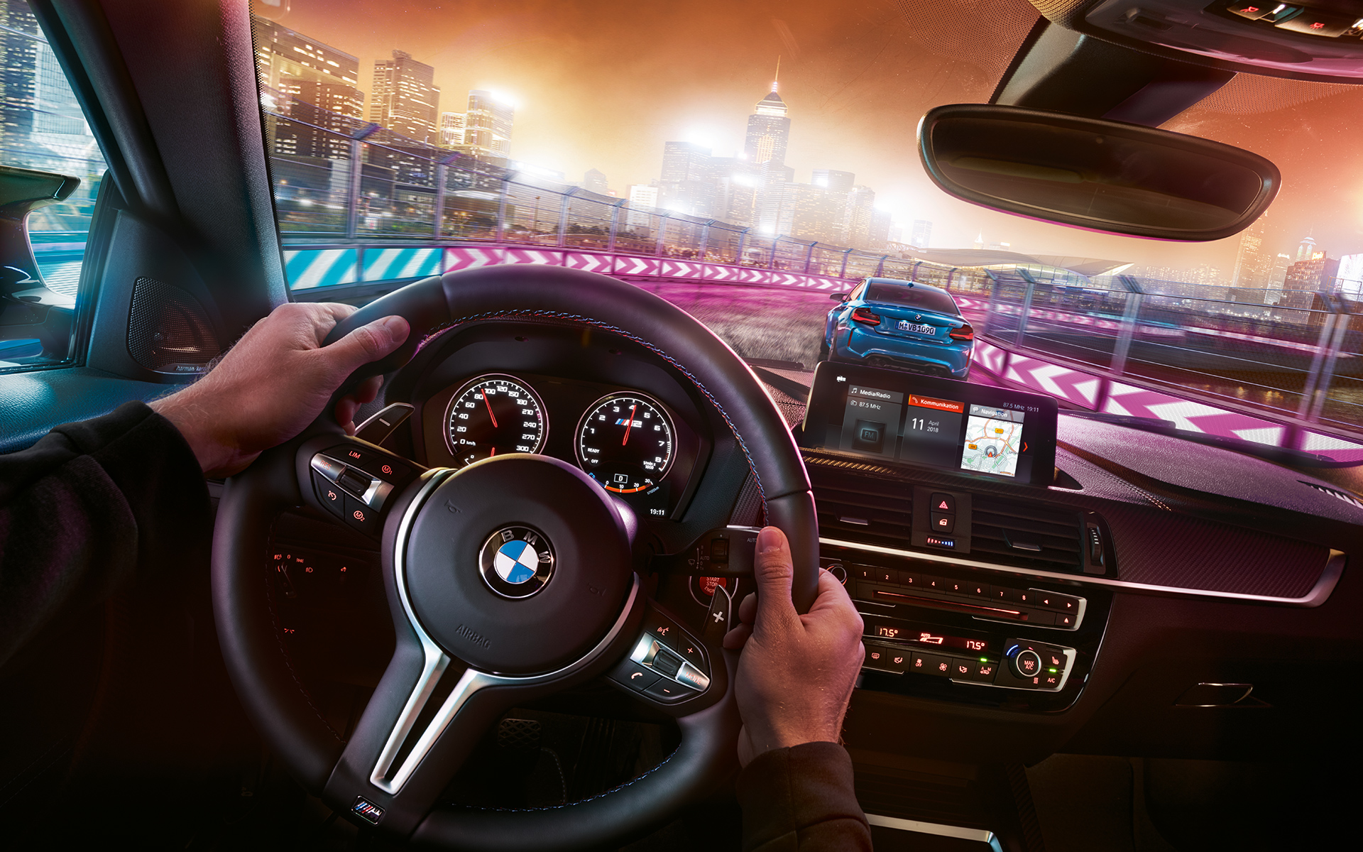 Kokpit BMW M2 Competition Dva BMW M2 Competition v dirkalnih razmerah ponoči, pogled iz kokpita.