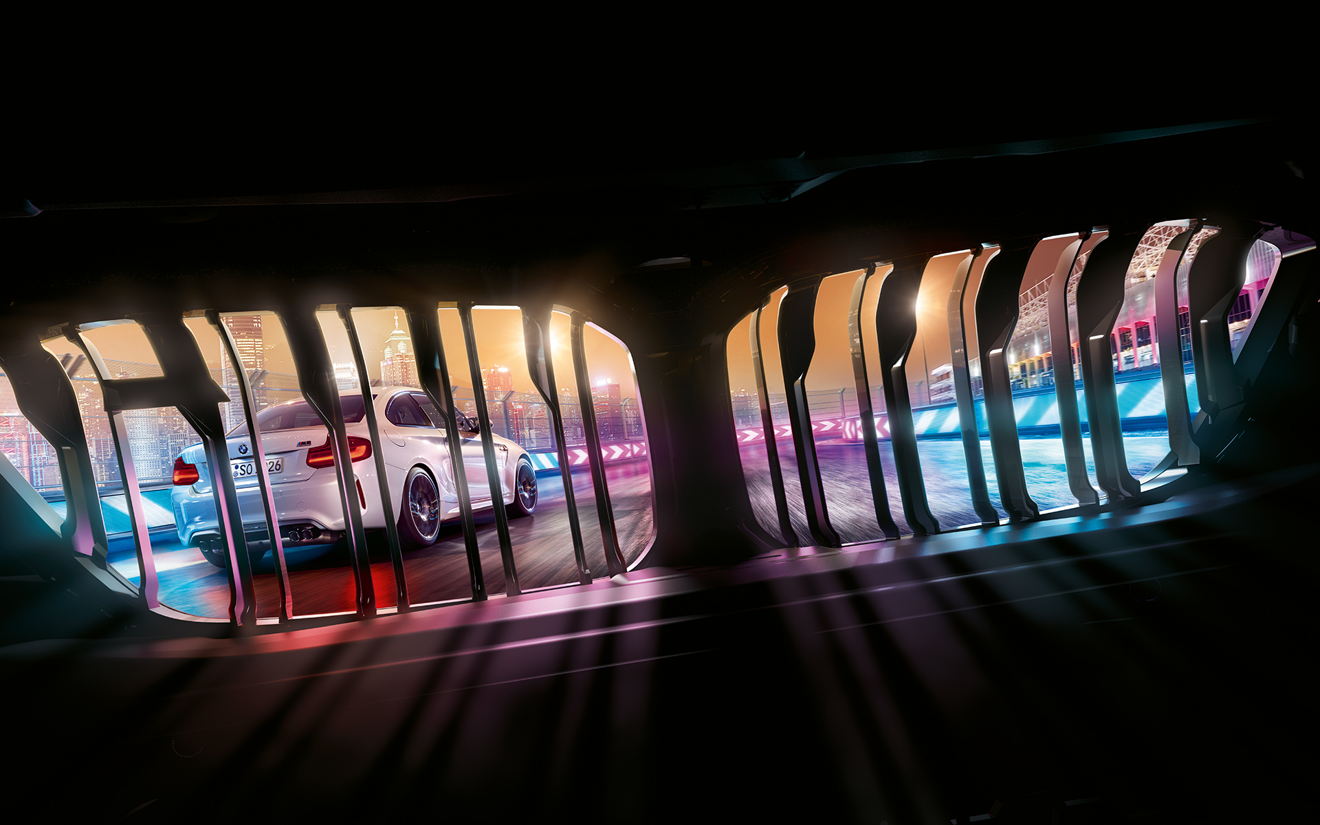 Ledvička BMW M2 Competition Pogled skozi ledvičko BMW na spredaj vozeči BMW M2 Competition na nočni stezi.