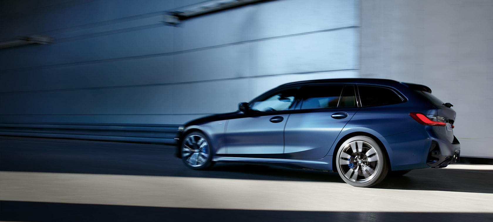 BMW M340i xDrive Touring, G21, barva Frozen Tanzanite Blue, tričetrtinski stranski pogled med vožnjo