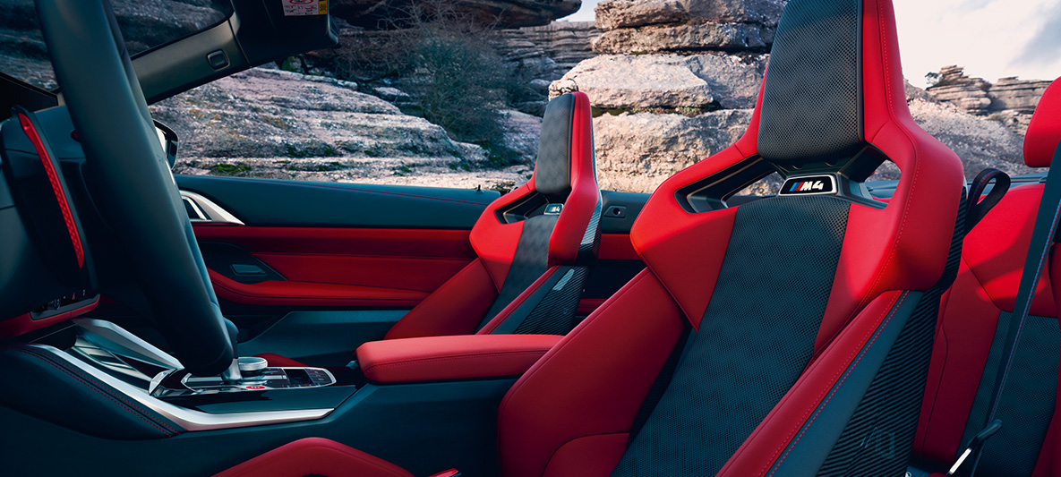 BMW M4 Competition Cabrio z M xDrive, G83, 2021, oblazinjenje BMW Individual iz usnja Merino v barvi Fiona Red/Black BMW M4 Competition Cabrio z M xDrive, G83, 2021, oblazinjenje BMW Individual iz usnja Merino v barvi Fiona Red/Black, notranjost, stranski pogled z odprto zložljivo platneno streho