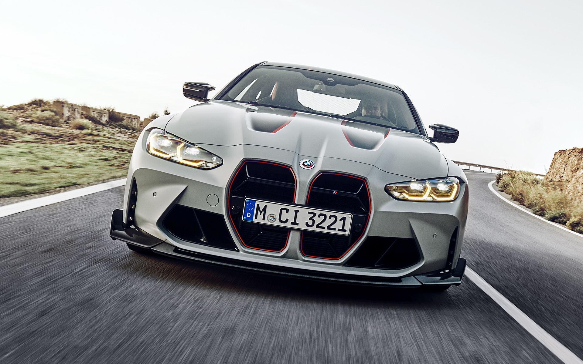 BMW M4 CSL, G82, prečke ledvičke v črni barvi z značilno rdečo folijo BMW M4 CSL, G82, lakiranje BMW Individual v kovinski barvi Frozen Brooklyn Grey, prečke ledvičke v črni barvi z značilno rdečo folijo, pogled od spredaj med vožnjo